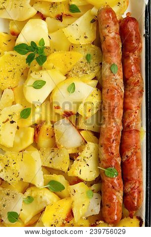 Tasy Baked Potato Slices With Fried Munich Sausages With Basil Leaves On A Baking Sheet