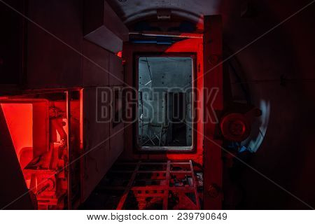Gateway Corridor Of Airlock Of Abandoned Bunker. Big Hermetic Door Illuminated By Red Lantern.