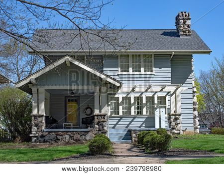 Blue House with Pergola & Heavy Stone Accents