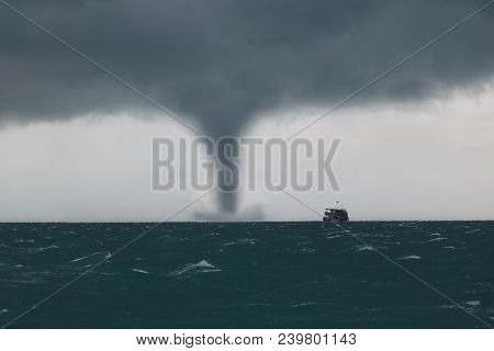 Tornado And Storm Cloud In The Sea While The Ship Is Sailing In The Ocean.