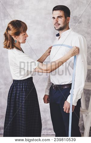 Woman Tailor Takes Measures With Male Models. Fashion Designer Sews A Costume For The Model