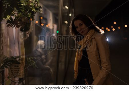 Girl Brunette Near In The Shopwindow On The Night City Street In A Cold Time