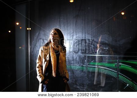 Girl Brunette Near In The Shopwindow On The Night City Street In A Cold Time