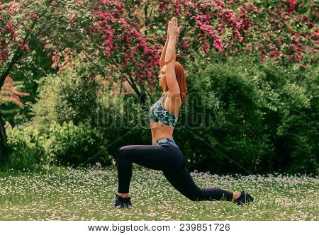 Redhead Female Doing Youga In The Summer Park.