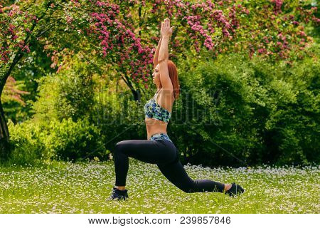 Redhead Female Doing Youga In A Summer Park.