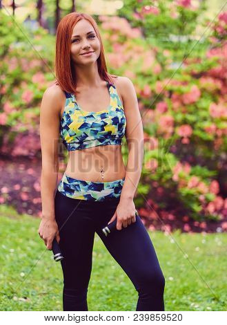 Redhead Female Doing Youga In A Summer Park.