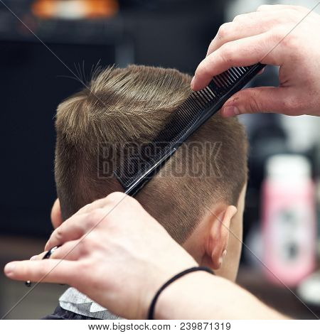 Hairdresser Is Making Haircut To Boy In Barbershop. Back View.