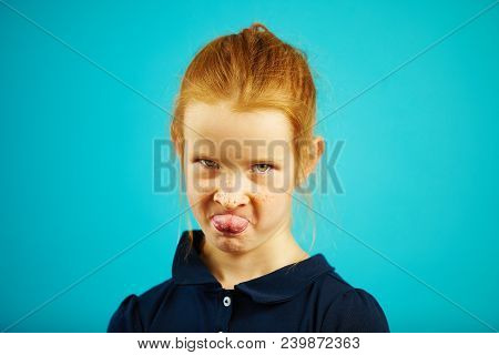 Angry Girl With Capricious Expression Of Resentment Shows Tongue, Has Red Hair And Freckles, Demonst