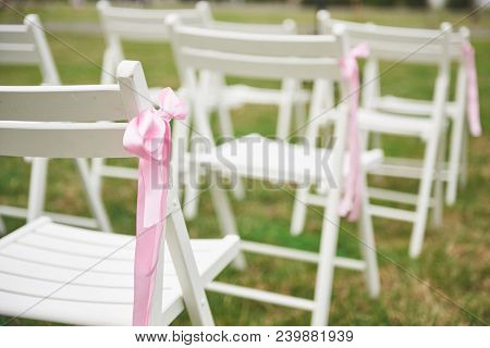 Freshly Cut Beautiful Red And Purple Wedding Flowers Garland On Chair.