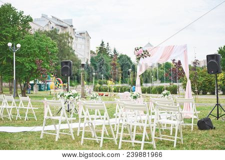 Freshly Cut Beautiful Red And Purple Wedding Flowers Garland On Chair.