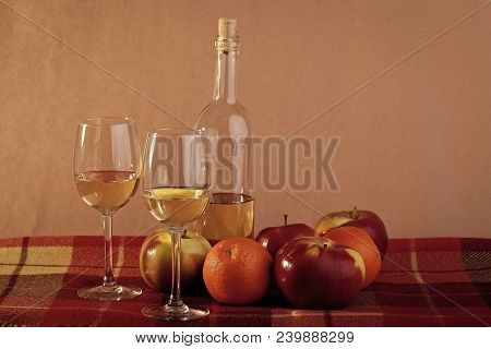 Still Life Of Uncorked Transparent Glass Bottle Of Semisweet White Wine With Two Filled Glasses Ripe