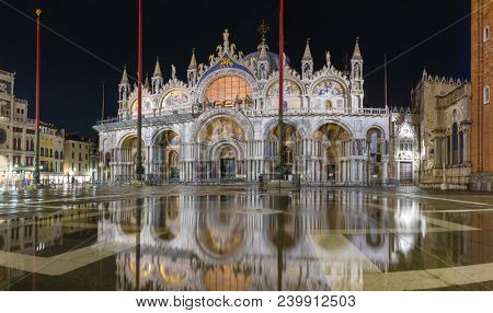 Basilica in San Marco square in Venice with reflection at night during the high tide, or aqua alta, that flooded the square with sea water