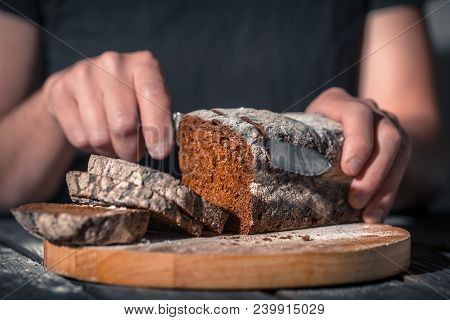 Baker Holding Fresh Bread In Hands