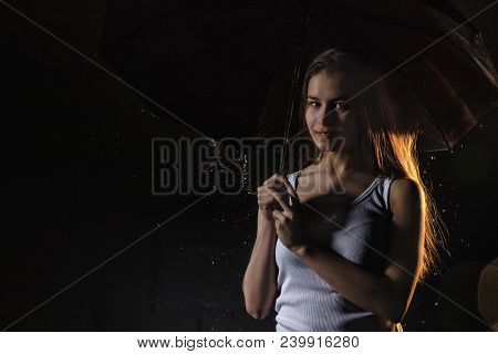 Girl Brunette In The White Shirt With Black Umbrella, Water Drops Around And Dark Walls Background