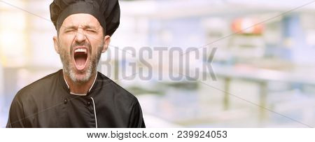 Senior cook man, wearing chef hat stressful, terrified in panic, shouting exasperated and frustrated. Unpleasant gesture. Annoying work drives me crazy at restaurant kitchen