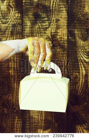 Female Hand Smeared In Golden Paint Or Glister Holding Yellow Paper Valentine Present Box On Brown V