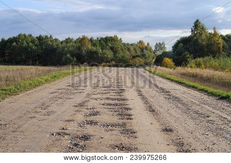 Bad Country Macadam Road With Many Pot-holes, Sunny Autumn Day