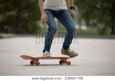 Young Woman Skateboarder Sakteboarding On Parking Lot