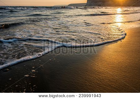 Waves Approaching Sandy Beach During The Sunset