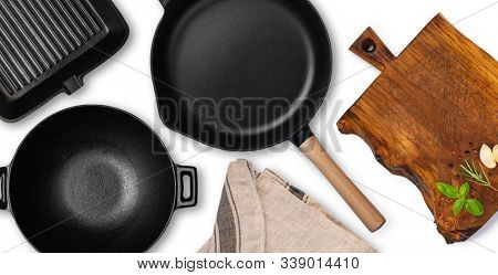 Empty cast iron frying pan over white background, view from above. Food background