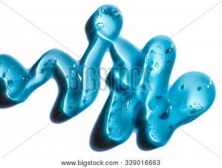 Squeezed cosmetic clear cream gel texture Iisolated on white background. Close up photo of transparent drop of skin care product. High Quality transparent gel serum with bubbles on white background