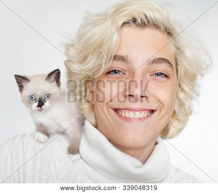 Cute cat at the shoulder young man. little kitten with teen