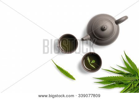 Tea Made From Cannabis Leaves ,a Glass Of Hot Marijuana Tea On White Background , Tea Pot And Cups O
