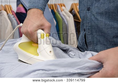 A Man Of About 30 Years Irons His Clothes With An Iron, Leads A Bachelor Lifestyle, Is Going To Visi