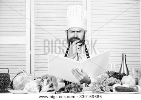 Ultimate Cooking Guide Step By Step. Book Recipes Copy Space. Man Chef In Hat And Apron Read Book. C