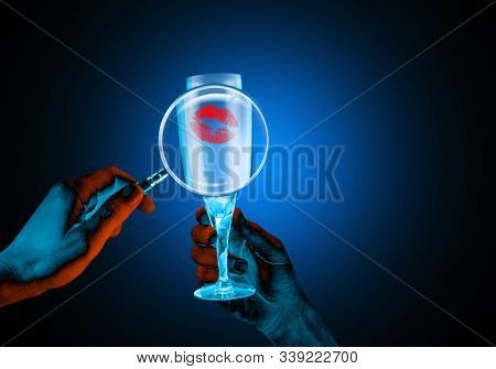 Wine Glass With A Lipstick Mark Magnified By A Magnifying Glass. Creative Blacklight Lighting.