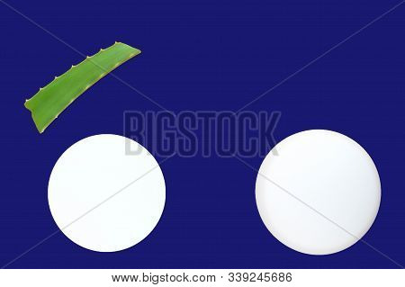 Aloe Vera Lef And White Cream Jars Of On A Deep Blue Background. Organic Cosmetics Concept. Top View