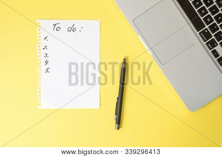 To Do List On White Sheet Torn From Spiral Notepad And Black Pen On Bright Yellow Table With Laptop 