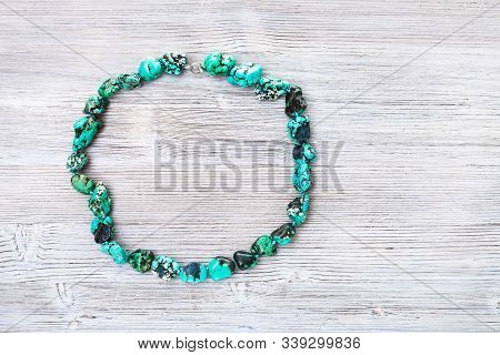 Top View Of Colored Howlite (turquoise Imitation) Necklace On Gray Wooden Board With Copyspace