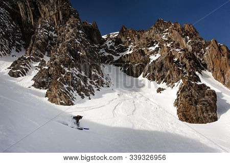 View Of Snowboarder Sliding Down The Mountain Side