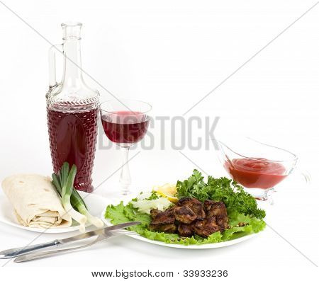 Appetizing weal kebab with wine and greens