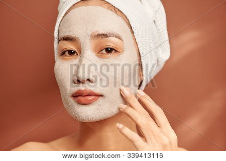 Young Beautiful Woman With Clay Mask On Her Face. Salon Skin Care, Natural Cream Of Algae.