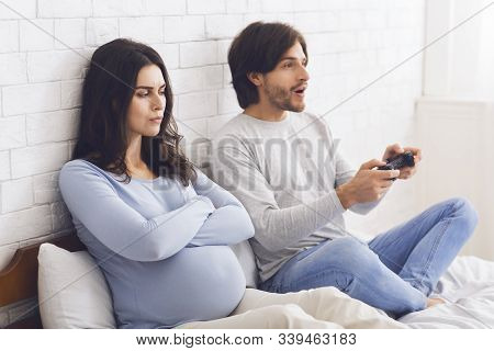 Pregnant Woman Angry To Her Husband Playing Video Games With Joystick And Not Giving Attention To He