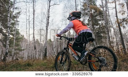 One Caucasian Children Rides Bike Road In Autumn Park. Little Girl Riding Black Orange Cycle In Fore