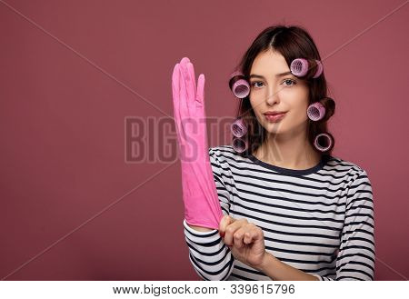 A Charming Young Girl With Blue Eyes And Perfect Skin Looks At The Camera And Puts On A Rubber Pink 