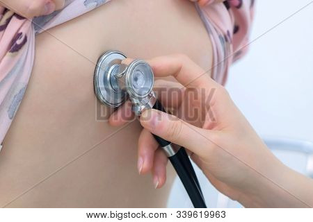 Doctor And Patient On Preventive Examination. Pediatrician Woman Listening To Heartbeat Heart, Lung 
