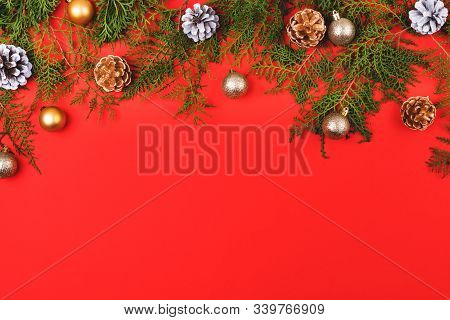 New Year Composition Made Of Christmas Balls, Cones And Striped Hard Candies On Red Background. Flat