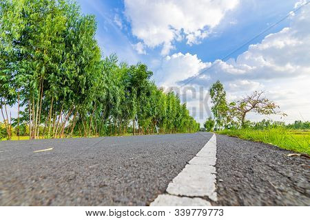 The Road At Contry Side And Tree Under Blue Sky With Beautiful Clouds.