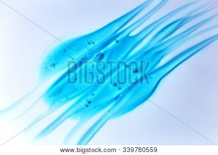 Squeezed cosmetic clear cream gel texture Iisolated on white background. Close up photo of transparent drop of skin care product. High Quality transparent gel serum with bubbles on white background