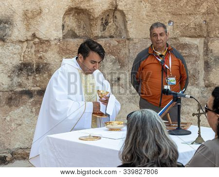 Ramla, Israel, December 07, 2019 : Priest Makes Communion At Collective Prayer On The Ruins Of A Byz