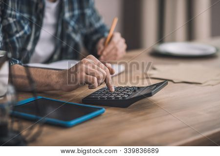Man Using A Calc And Other Gadgets For Financial Estimation