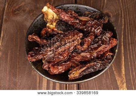 Lot Of Whole Dried Red Tomato Piece In Glazed Bowl Flatlay On Brown Wood