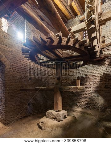 Aged Water Mill Turning Inside Weathered Mill Building At Amir Taz Palace, Medieval Cairo, Egypt