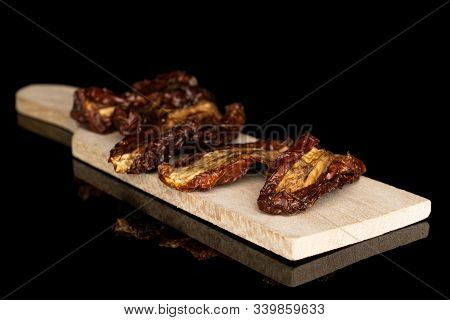 Group Of Five Whole Dried Red Tomato Piece On Wooden Cutting Board Isolated On Black Glass