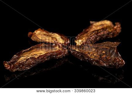 Group Of Four Whole Dried Red Tomato Piece Isolated On Black Glass