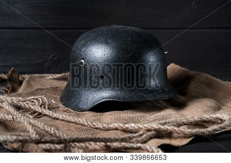 Still Life German Helmet And Heavy Cartridge On A Black Background And Burlap